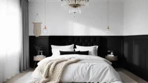 "Monochrome bedroom with black accent wall, white bedding, gold accents, and natural morning light"